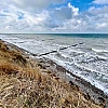 Im Vordergrund das Hohe Ufer im Hintergrund das stürmische Meer.