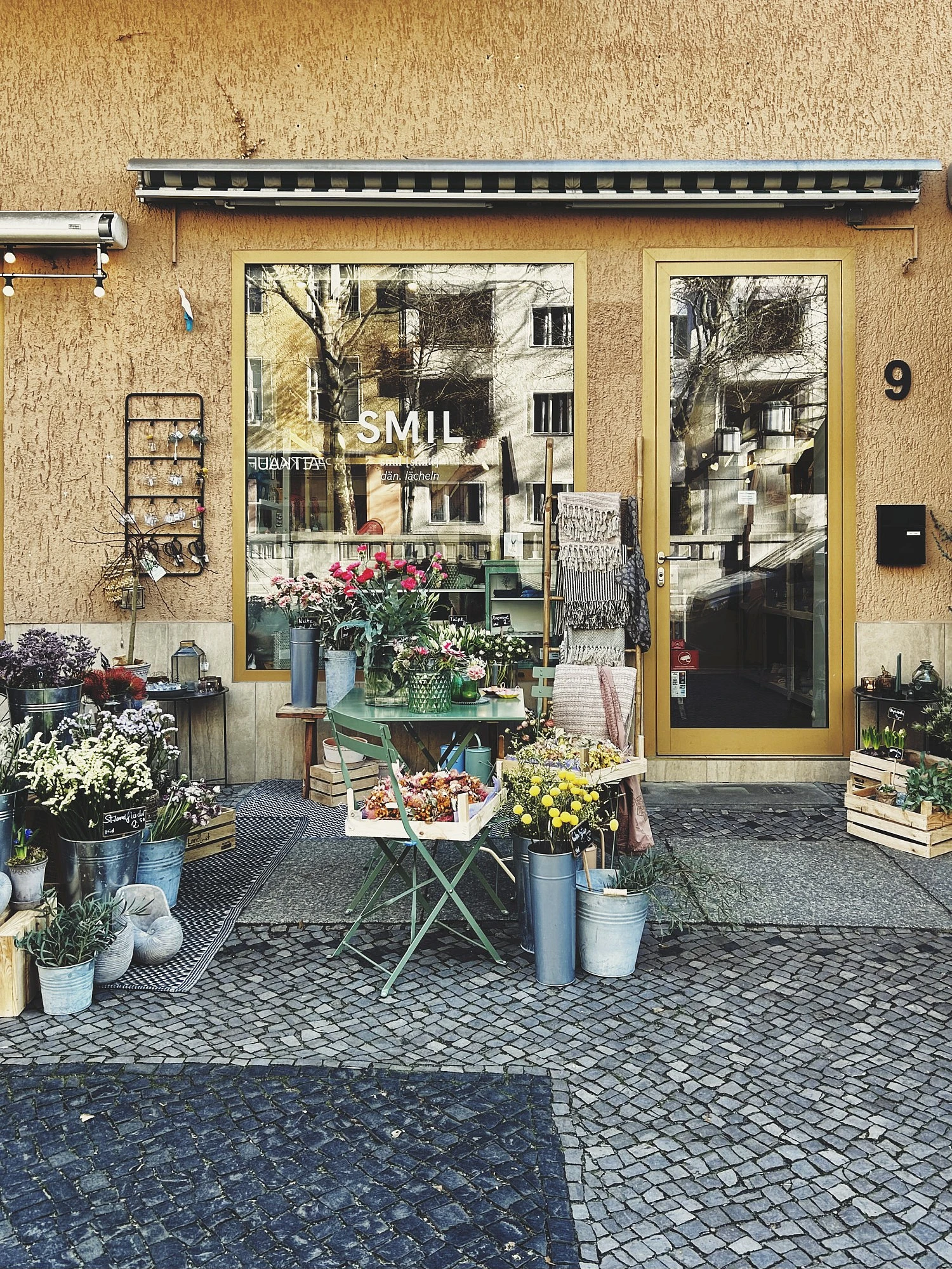 Foto eines Geschäfts mit Blumen davor. Auf der Scheibe steht SMIL in Großbächstaben für dänisch Lächeln