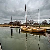 Ein Zeesboot liegt im Wecker Hafen. Der Himmel ist wolkenverhangen.