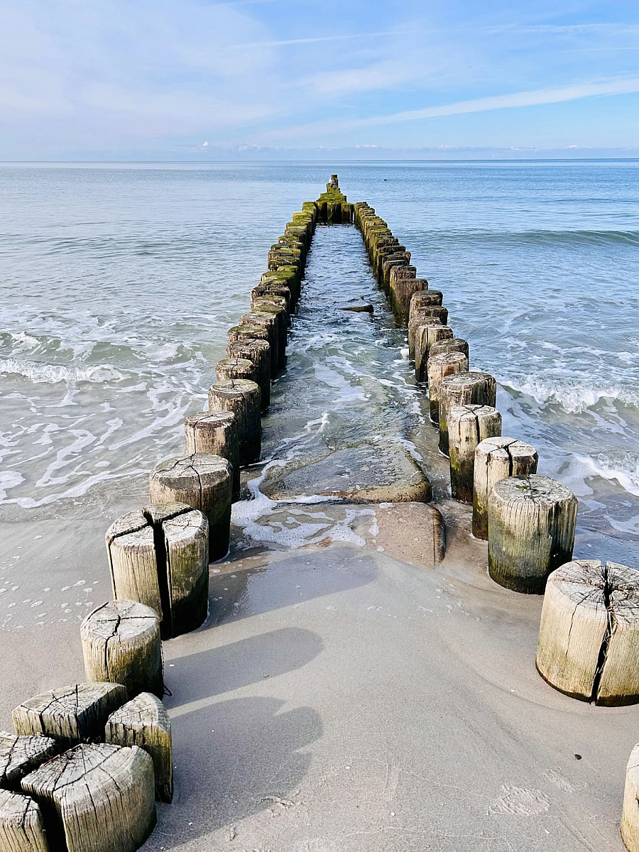 Blick auf die ruhige Ostsee, die ebenso wie der Himmel blau ist. Leichte Schleierwolken ziehen zum Horizont.