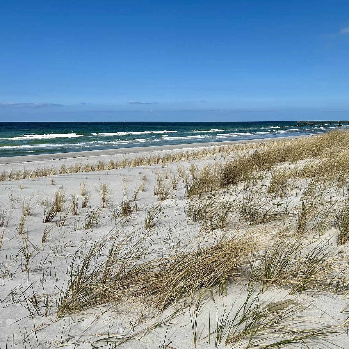 Standkörbe auf Sandstrand bei blauem Himmel im Sonnenschein