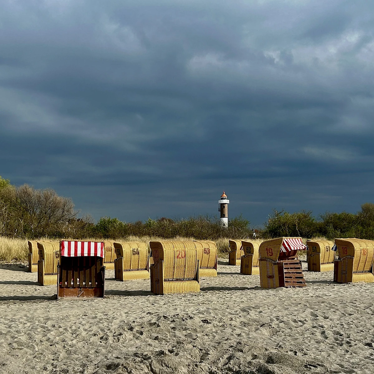 Standkörbe auf Sandstrand bei blauem Himmel im Sonnenschein
