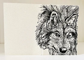 Foto eines aufgestellten und aufgeklappten Traveler's Notebooks in der Passport-Größe. Über den Rücken erstreckt sich die schwarze Zeichnung eines Wolfes auf grauem Grund.