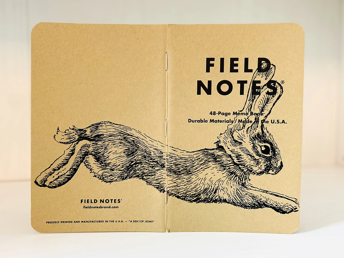Aufgeklapptes Field Notes Heft. Auf dem Rücken die Illustration eines von links nach rechts springenden Hasen.