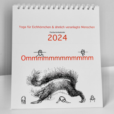 Der Kalender Ommmmmmmmmmmm - Yoga für Eichhörnchen & ähnlich veranlagte Menschen - Postkartenkalender 2024  steht aufgeklappt auf einer weißen Fläche. Auf dem Cover ist ein Eichhörnchen zu sehen, das die Position des herabschauenden Hundes praktiziert.  Fünf Haselnüsse praktizieren ebenfalls Yoga.