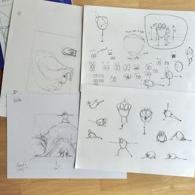 Viel Bleistiftskizzen auf weißem Papier auf einem Holztisch.