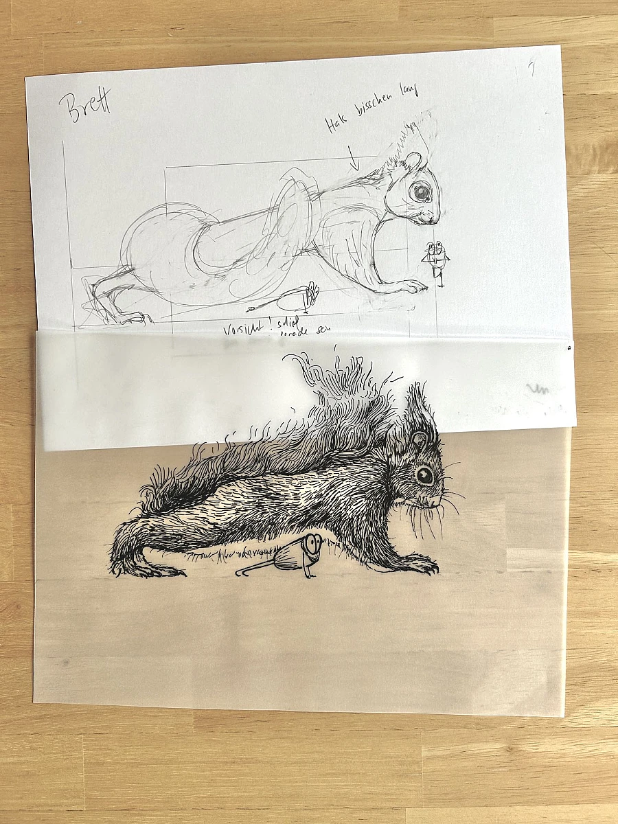 Vier Blätter Transparentpapier mit Tintezeichnungen liegen übereinander auf einem Holztisch. Links oben ein Hahnemühle Entwurfsblock.