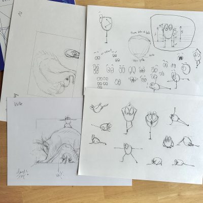 Viel Bleistiftskizzen auf weißem Papier auf einem Holztisch.