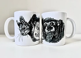 Zwei weiße Keramiktassen stehen nebeneinander. Auf der linken Tasse die schwarze Zeichnung eines Eichhörnchenkopfes, auf der rechten die schwarze Zeichnung eines Faultiers.